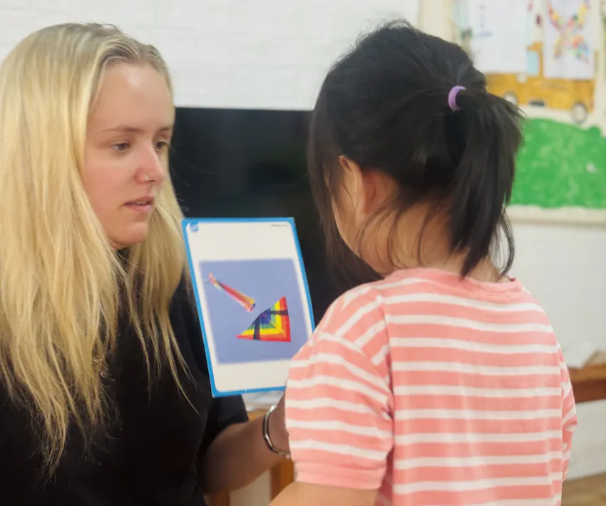 Jessica Chadwick playing an educational game with a young girl during a childcare volunteer project in Vietnam